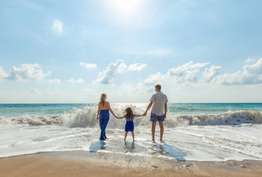 Familie entspannt am Strand und auf Immobiliensuche