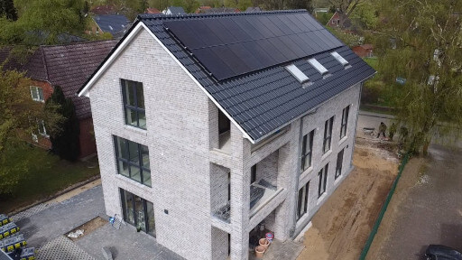Ein Mehrfamilienhaus mit Photovoltaikanlage auf dem Dach ist fast fertig gebaut. Photovoltaikanlagen gelten als Gemeinschaftseigentum.