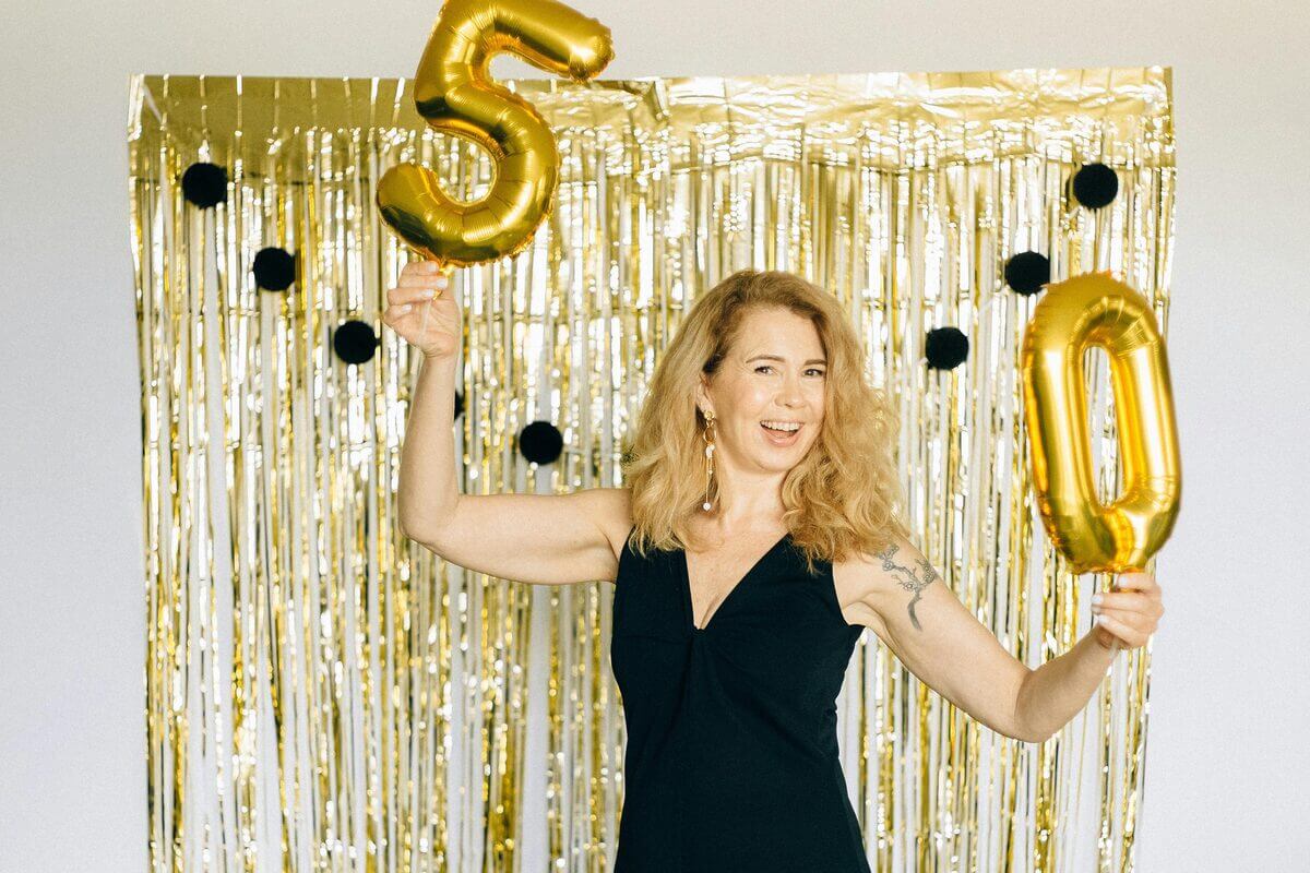 Frau am Geburtstag mit 50er-Luftballons
