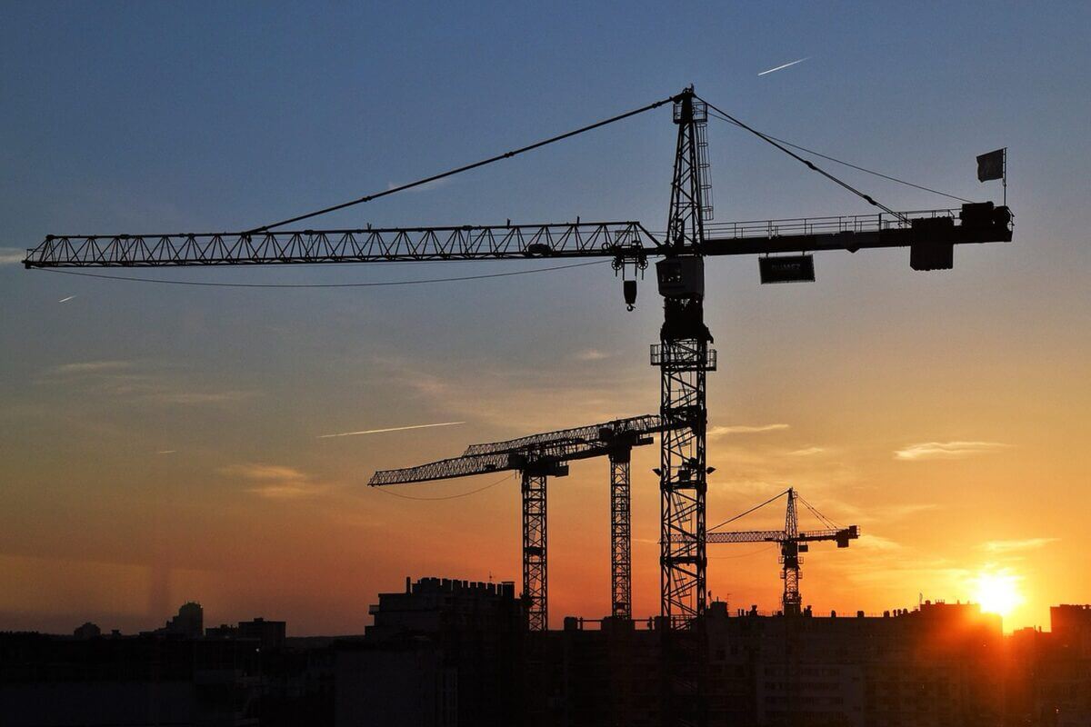 Abendrot über Baustelle mit Blick auf Kräne