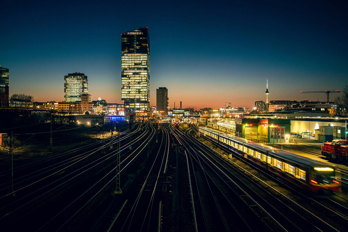 Berliner Skyline mit Bahngleisen in der Abenddämmerung